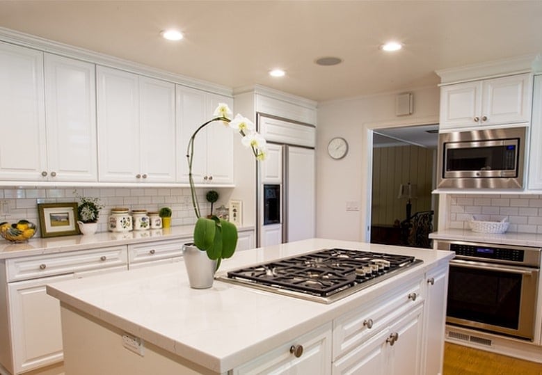 white kitchen with Cambria counter top island stove orchid view Leslie Kate photo